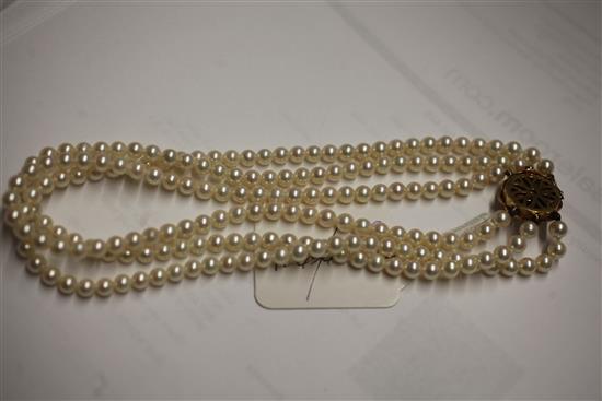 A 1980s triple strand cultured pearl choker necklace with 18ct gold and diamond cluster set clasp, 36cm.